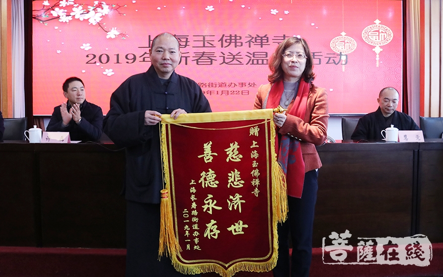 办事处主任赵平代表受助的困难居民向玉佛禅寺赠送锦旗(图片来源:菩萨
