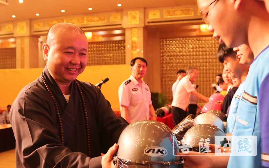 摄影-安全从“头”开始 上海玉佛禅寺和觉群文教基金会向市民捐赠1000顶头盔